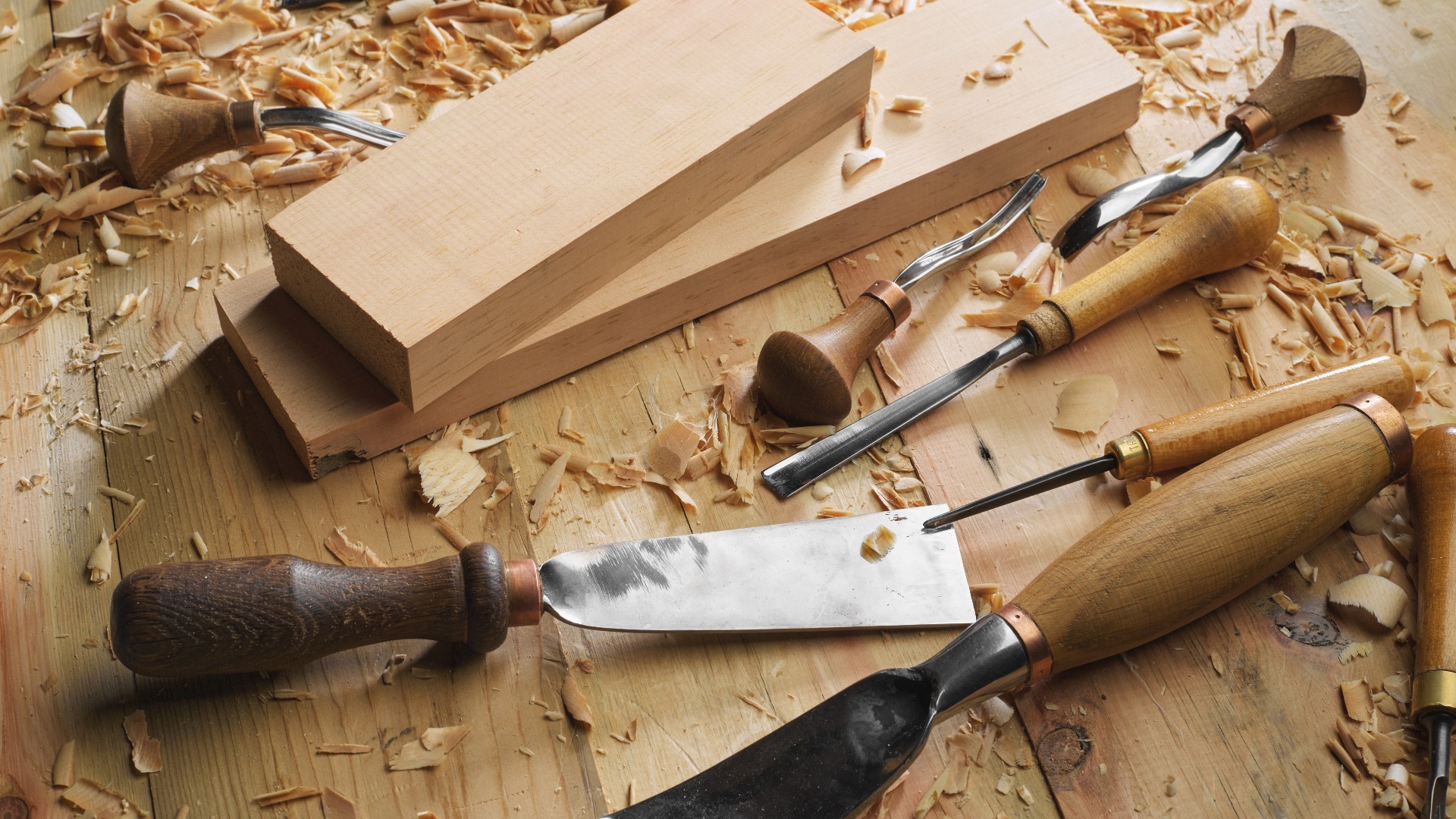 Holzbearbeiter. Holz, Holzverarbeitung. Tischlerarbeiten. Holzschnitzerei mit Werkzeugen in Großaufnahme. Hand des Schnitzers beim Schnitzen von Holz. Handwerker schnitzt mit einem Stechbeitel